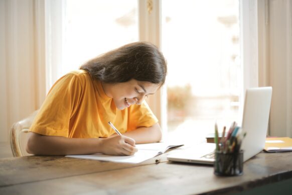 female student smiling and getting work done at virtual school