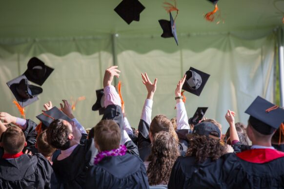 high school students throwing their caps into the air because they graduated