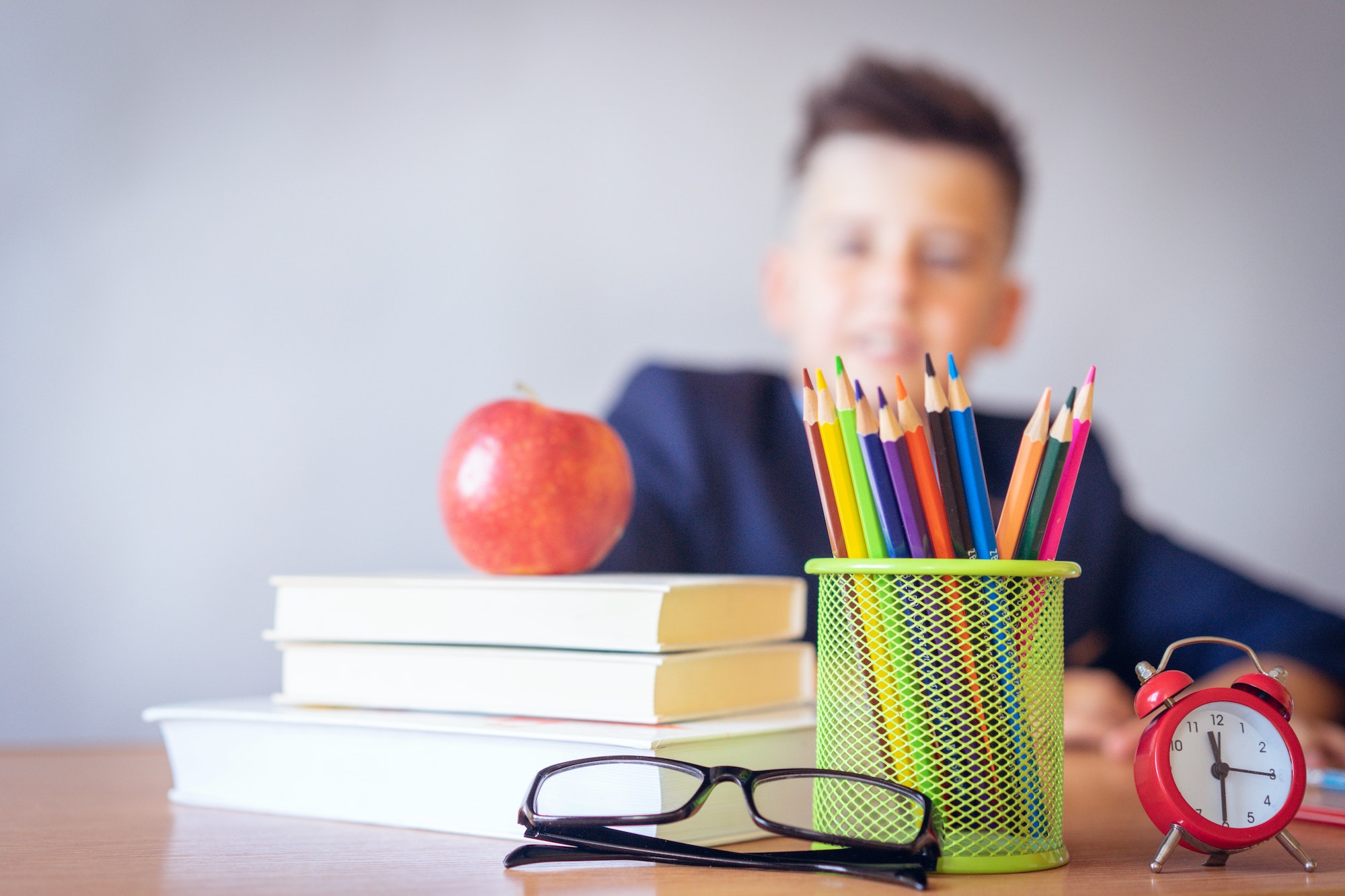 student doing virtual school at a desk with an apple on it