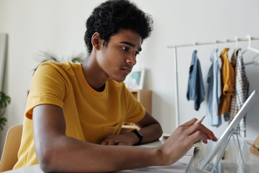 african american male student doing homework for virtual high school