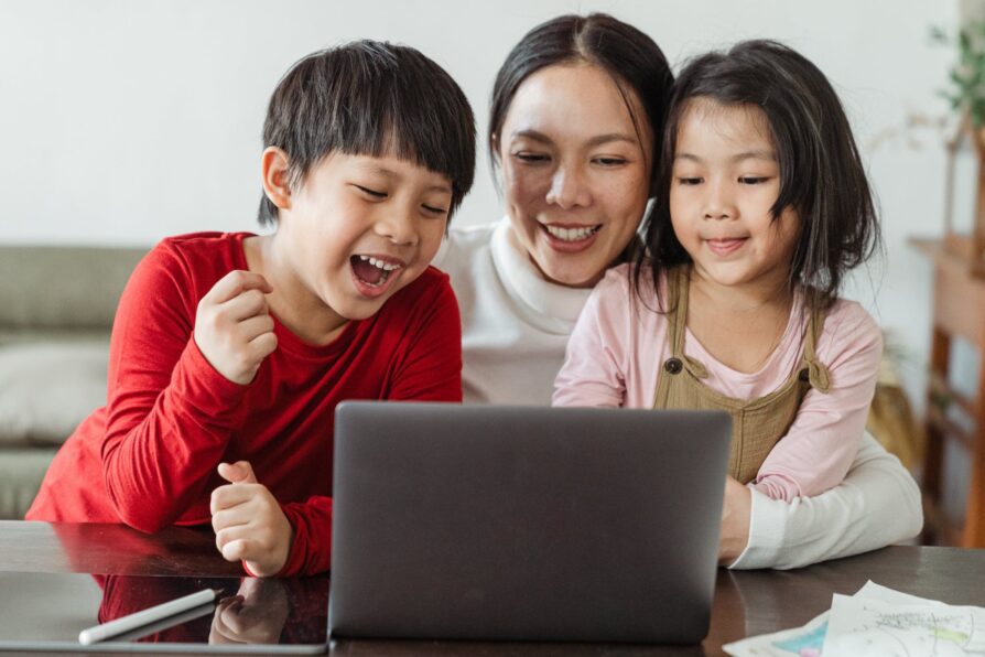 asian parent helping her two kids with virtual school