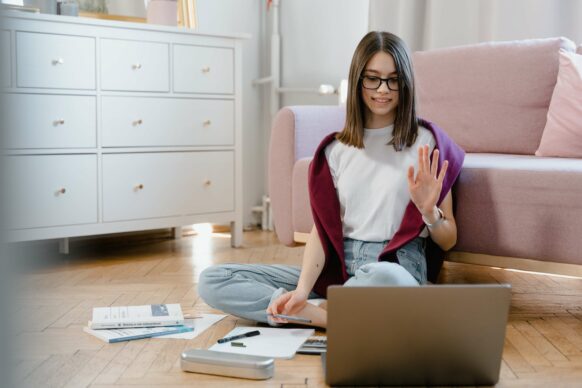 student sitting on floor in front of laptop