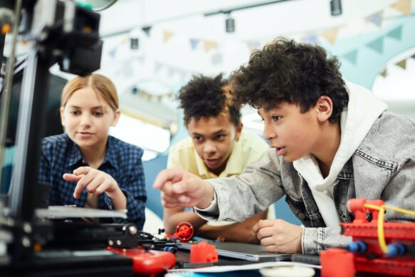 three students gathered around computer