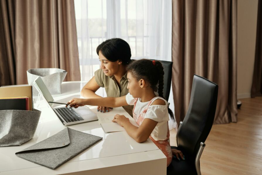 learning coach working with student on an assignment