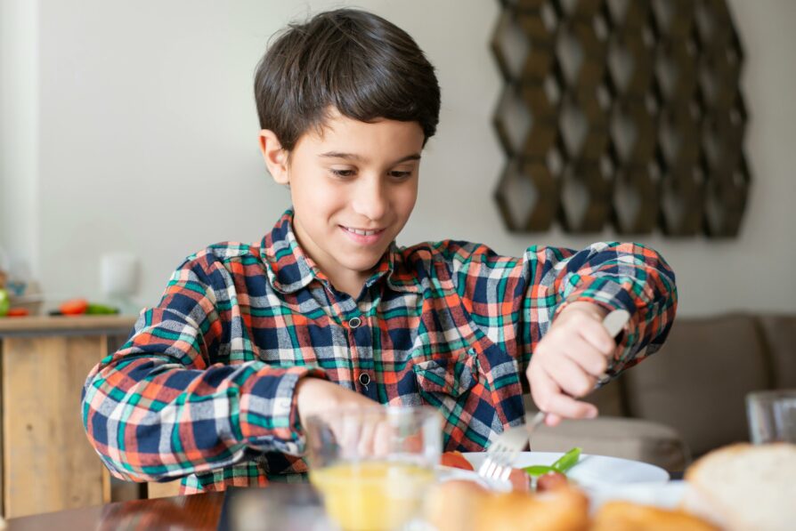 young kid eating breakfast before school