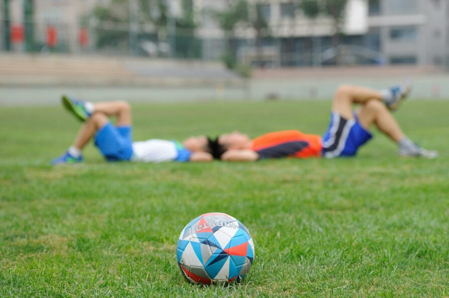 two boys laying on the grass after soccer practice in portland, oregon