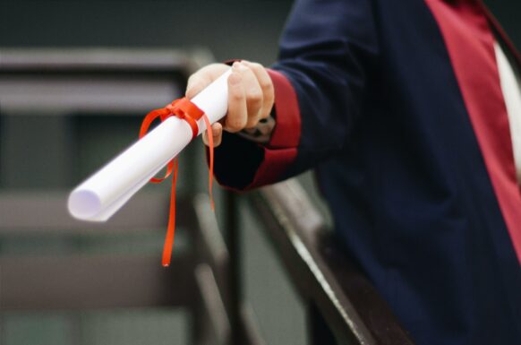 teacher handing out the diploma to a graduating student