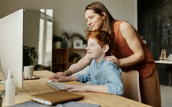 learning coach helping student with homework on the computer