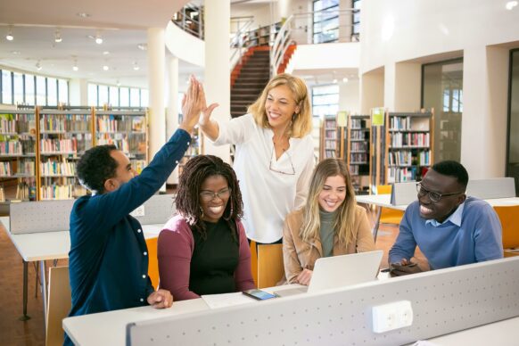 high school students working on a group project with their teacher
