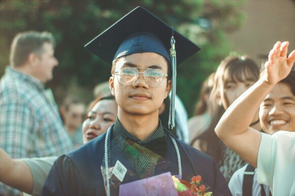 asian male student wearing graduation cap