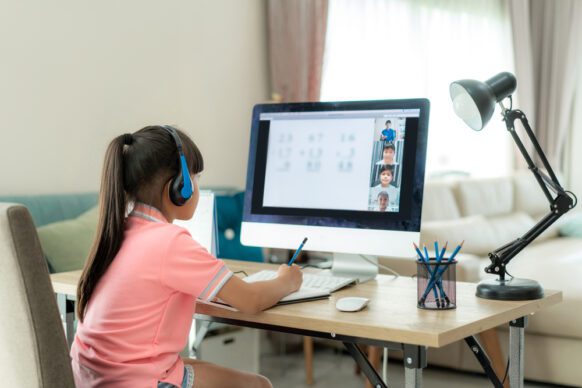 young girl in elementary virtual school participating in class