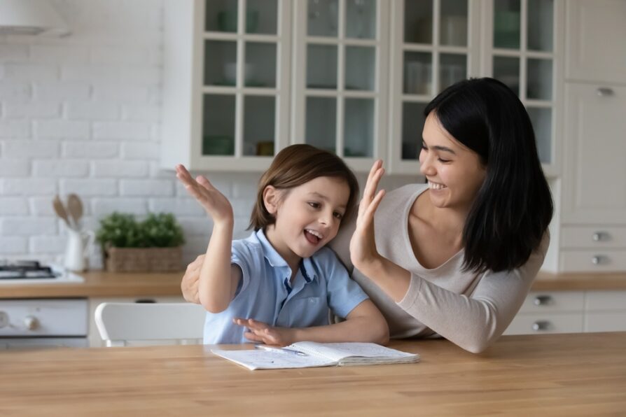 asian mom giving her son a high five after competing homework