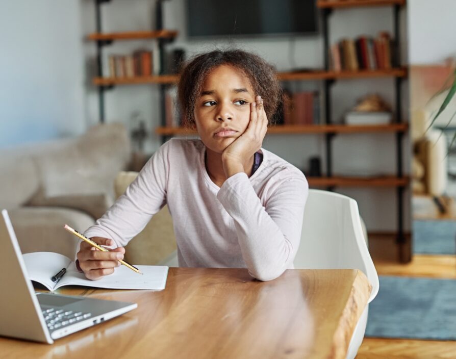 african american female getting distracted while doing homework